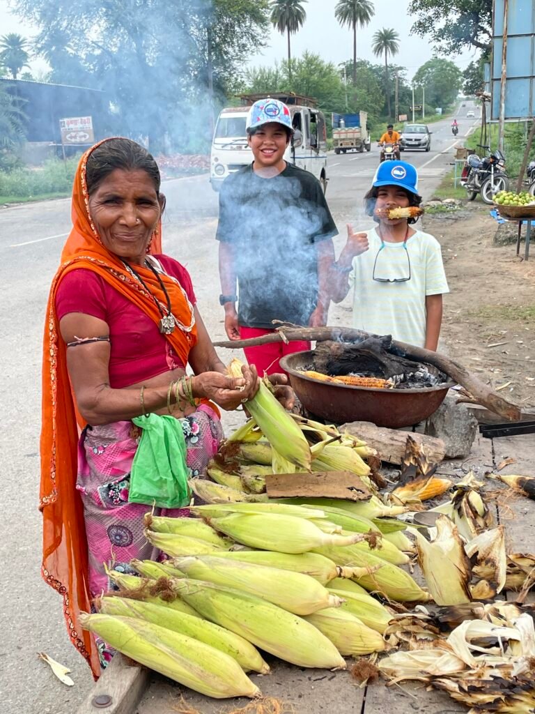 woman selling street corn in India, family street food India