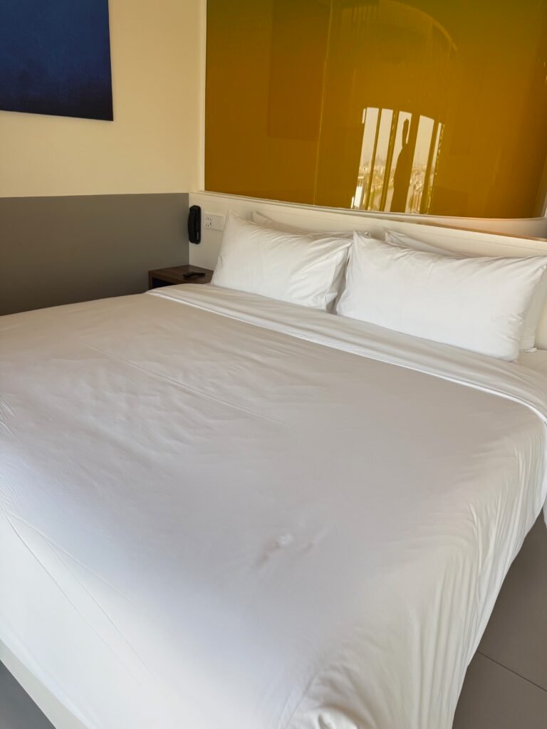 King bed with white linens at Wink Hai Phong